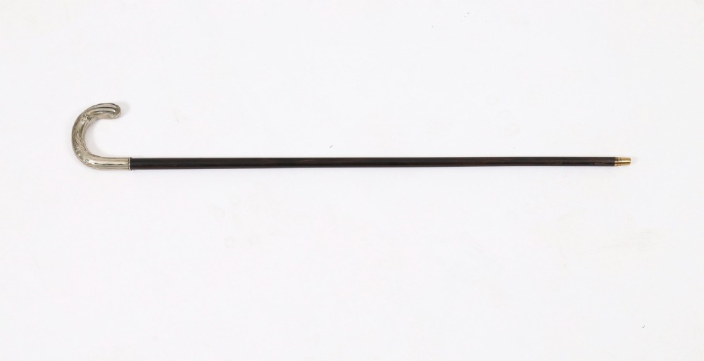 A 19th-century French Art Nouveau walking cane featuring a silver-plated crook handle decorated with foliate reliefs attached to a dark wooden shaft. View II