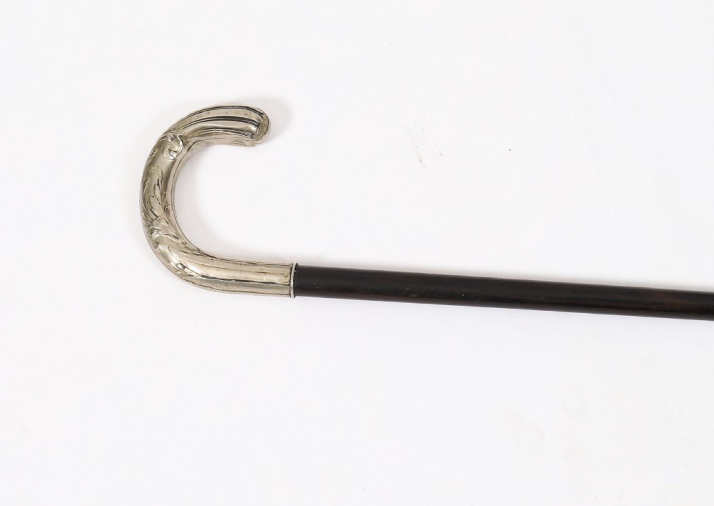 A 19th-century French Art Nouveau walking cane featuring a silver-plated crook handle decorated with foliate reliefs attached to a dark wooden shaft. View III