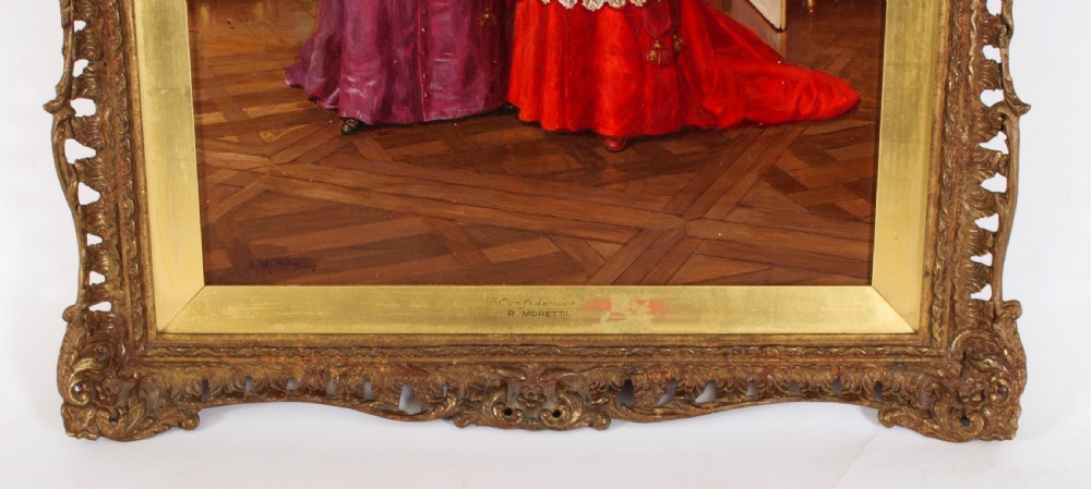 A 19th-century oil painting depicting two Catholic clergymen in red and purple robes conversing inside an ornate room, enclosed in a carved gilt frame. View V