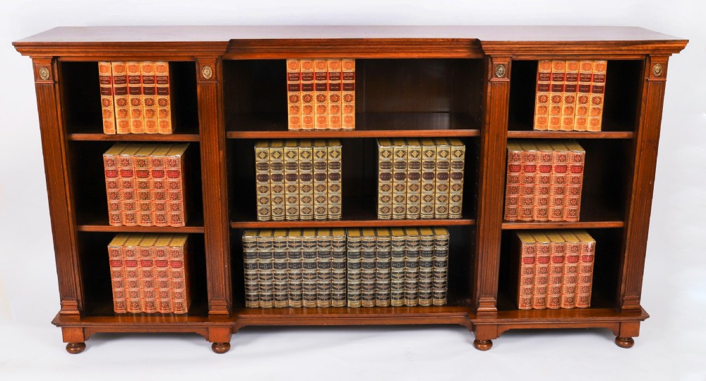 A wide Victorian open bookcase crafted in dark polished walnut with three bays of adjustable shelves, fluted pilasters adorned with circular ormolu mounts, and short turned feet. View III