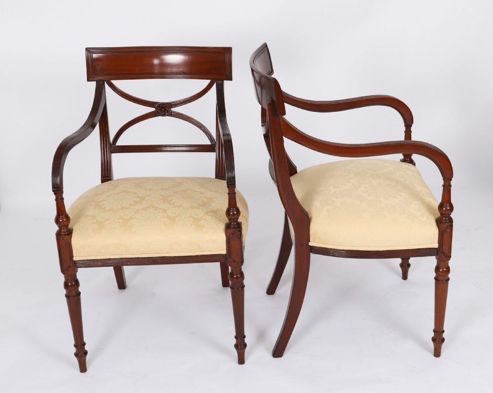 A set of eight Regency mahogany dining chairs with carved X-frame splats, reeded turned front legs, and light damask upholstered seats. View II