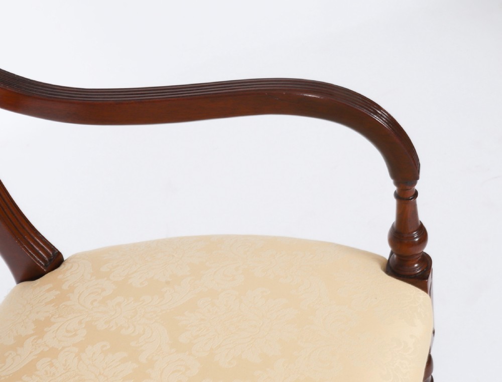 A set of eight Regency mahogany dining chairs with carved X-frame splats, reeded turned front legs, and light damask upholstered seats. View VIII