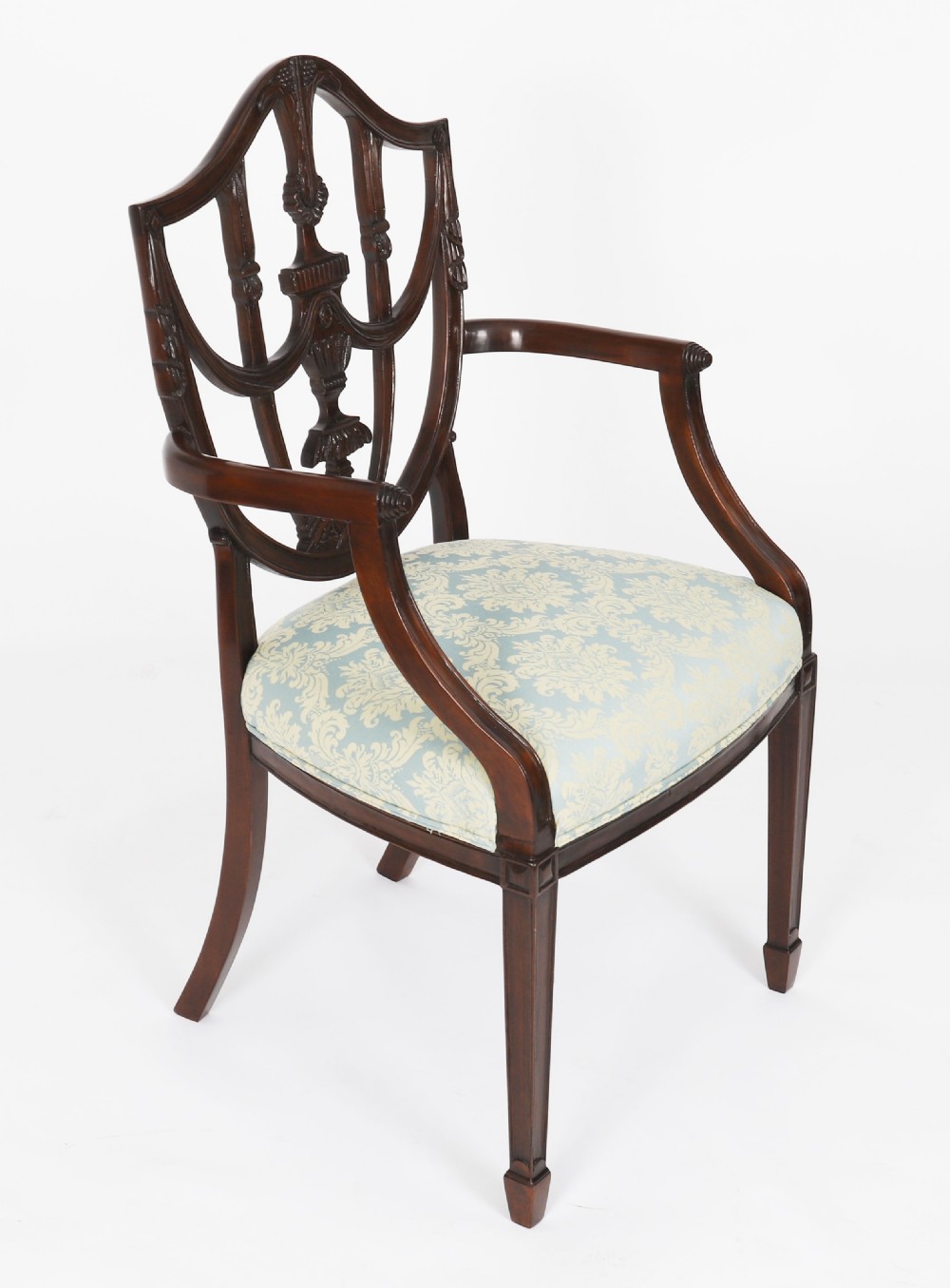 A large set of sixteen mahogany dining chairs featuring carved shield backrests and light blue patterned upholstered seats. View II