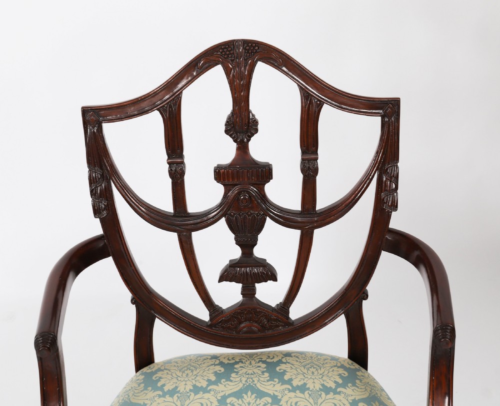 A large set of sixteen mahogany dining chairs featuring carved shield backrests and light blue patterned upholstered seats. View IV