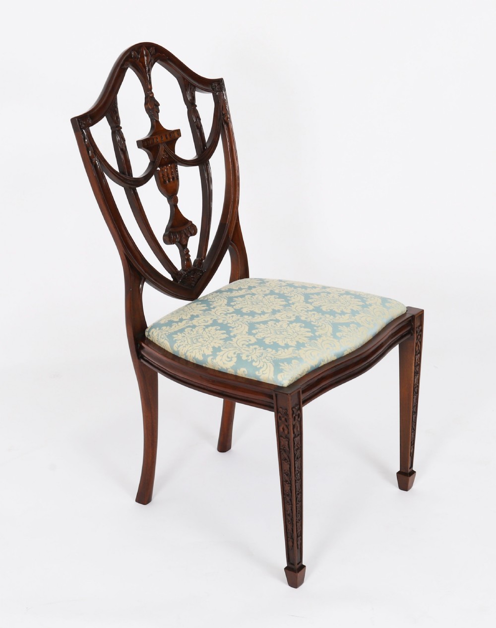 A large set of sixteen mahogany dining chairs featuring carved shield backrests and light blue patterned upholstered seats. View X