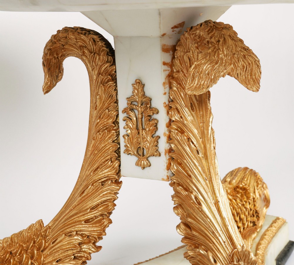 A circular centre table featuring an intricate geometric inlaid marble top supported by three carved gilt dolphin figures on a triform marble base. View XII