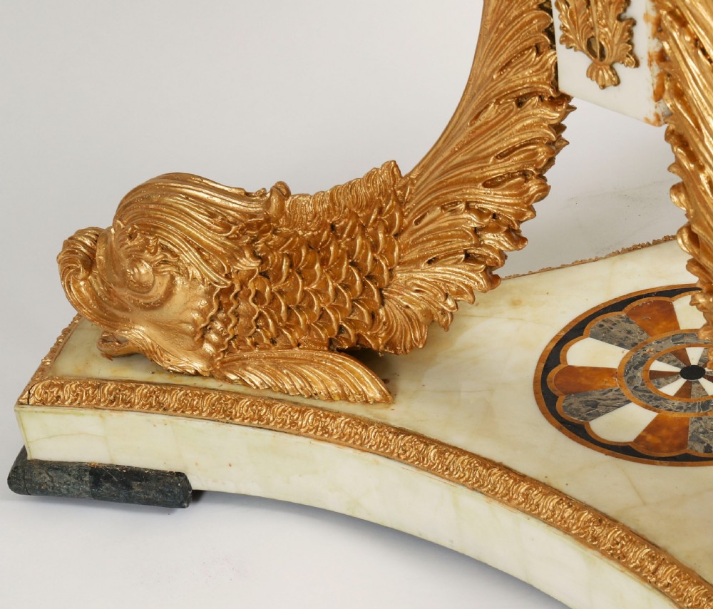 A circular centre table featuring an intricate geometric inlaid marble top supported by three carved gilt dolphin figures on a triform marble base. View XIII