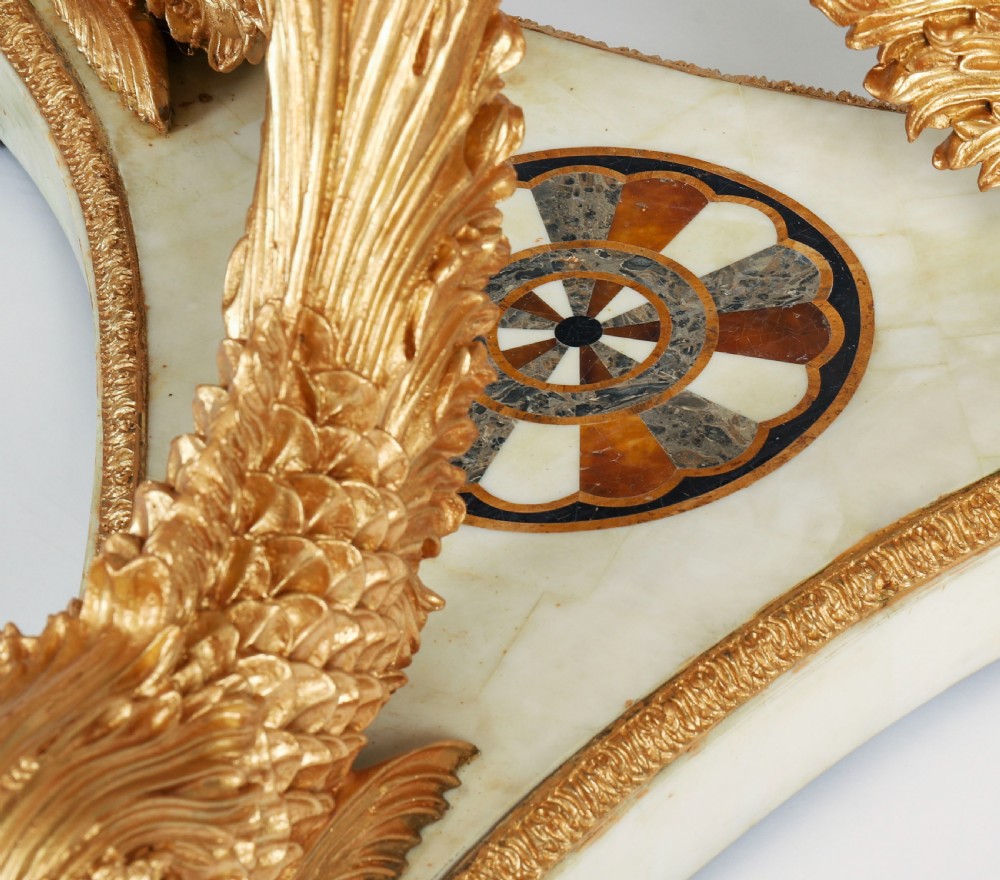 A circular centre table featuring an intricate geometric inlaid marble top supported by three carved gilt dolphin figures on a triform marble base. View XIV