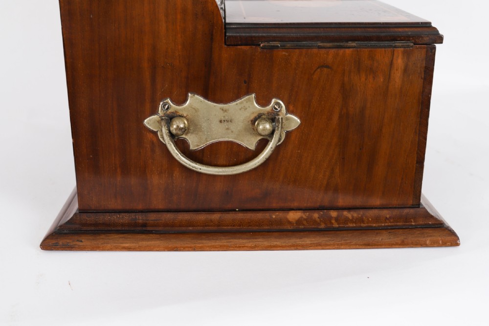 A 19th-century inlaid mahogany tantalus box containing three cut crystal decanters arranged in front of a mirrored back. View VI