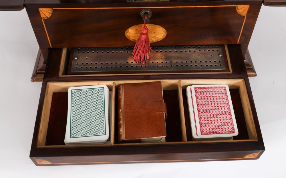 A 19th-century inlaid mahogany tantalus box containing three cut crystal decanters arranged in front of a mirrored back. View X