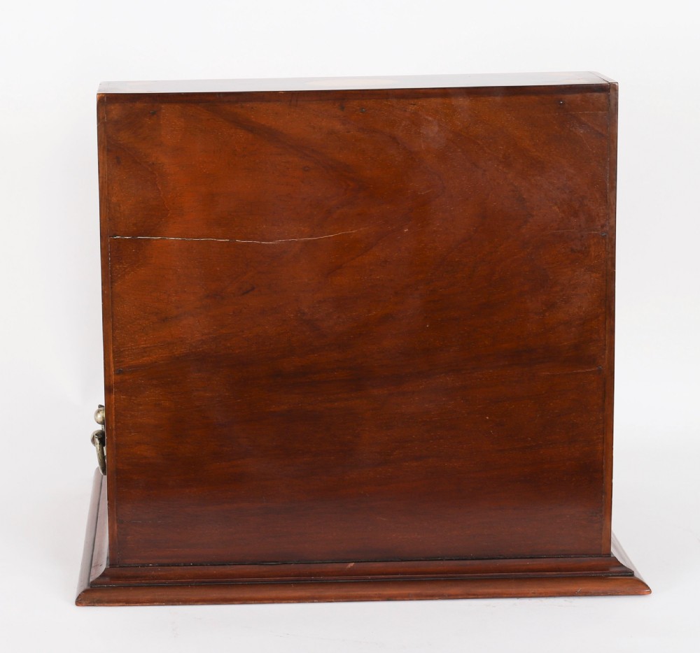 A 19th-century inlaid mahogany tantalus box containing three cut crystal decanters arranged in front of a mirrored back. View XI