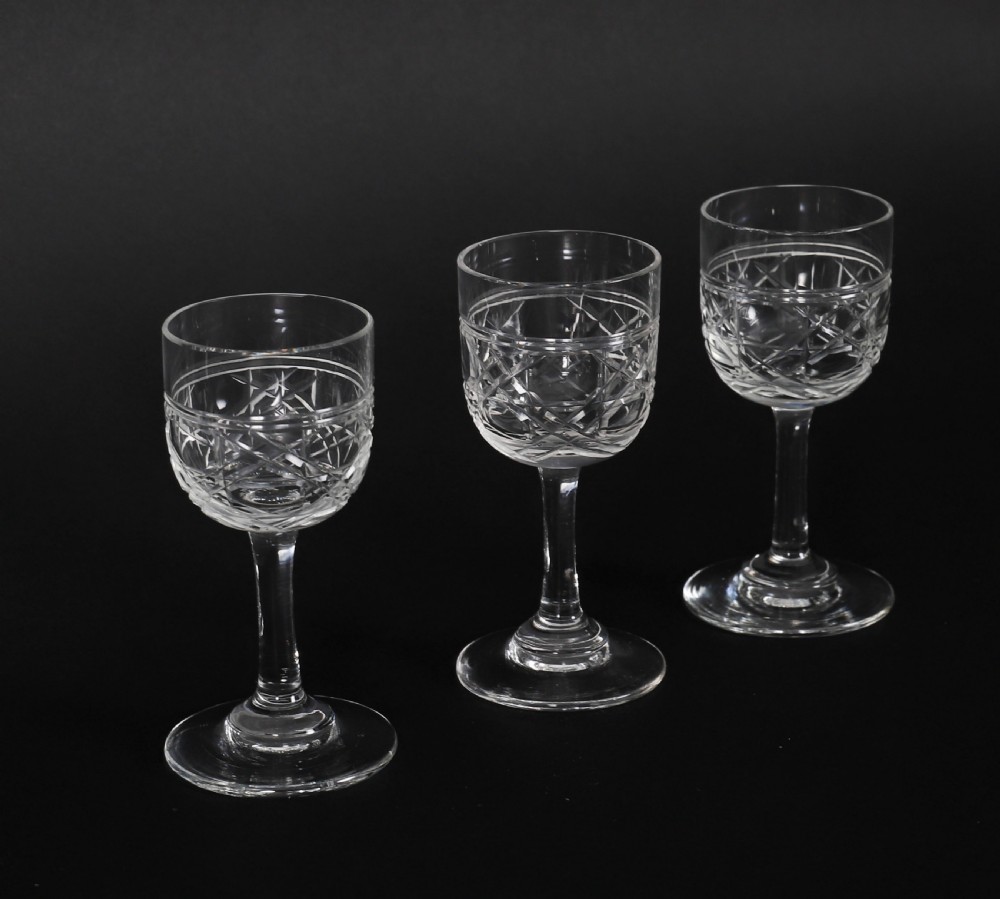 A 19th-century inlaid mahogany tantalus box containing three cut crystal decanters arranged in front of a mirrored back. View XVIII