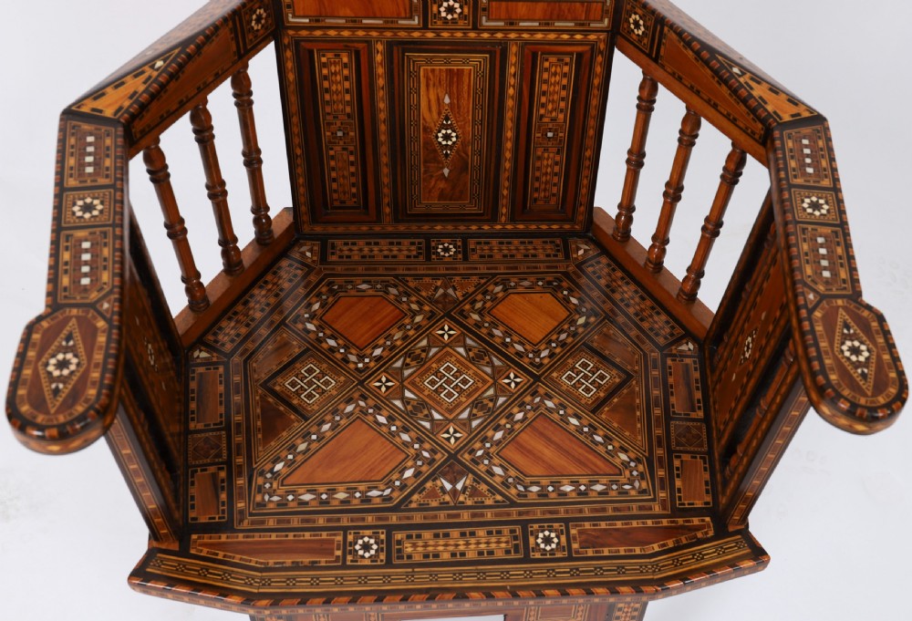A pair of 19th-century Levantine armchairs decorated with geometric wood parquetry, mother-of-pearl inlay, turned side spindles, and stepped crest rails. View VI