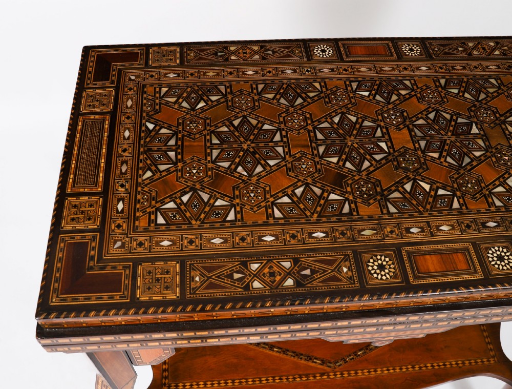 A nineteenth-century wooden games table decorated with geometric micro-mosaic marquetry, mother-of-pearl inlay, cabriole legs, and a lower shelf. View VIII