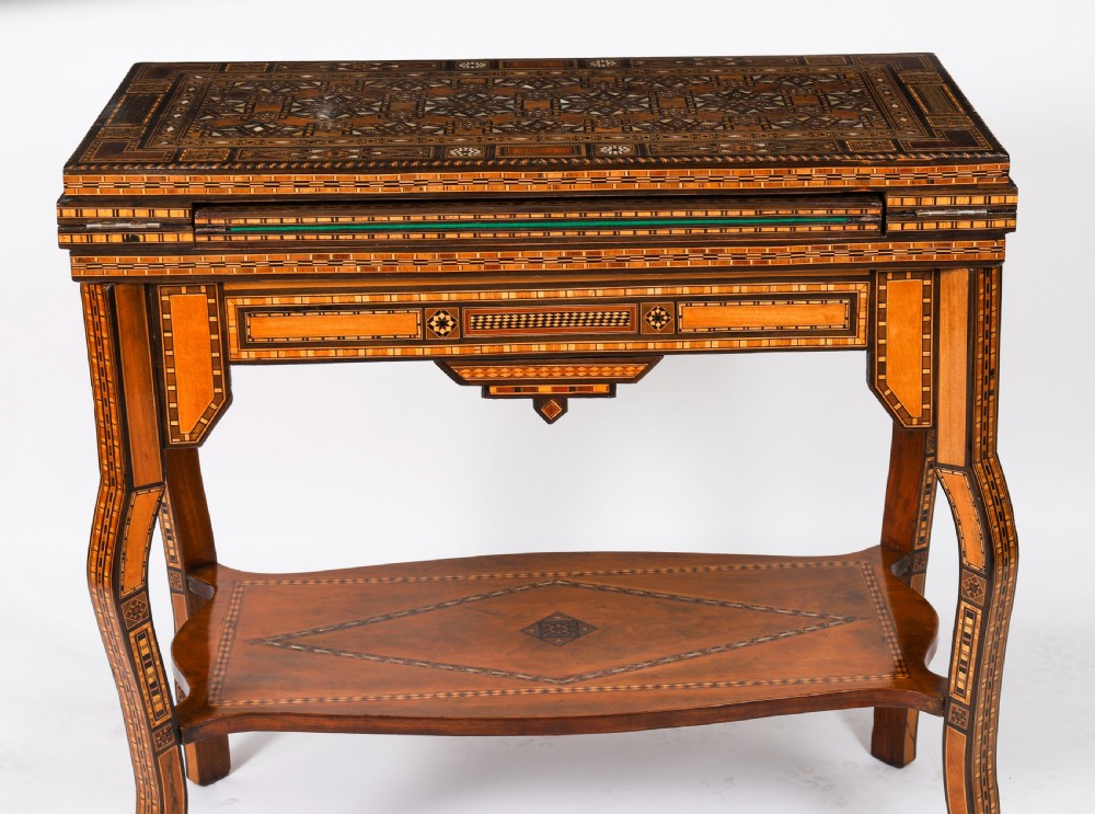A nineteenth-century wooden games table decorated with geometric micro-mosaic marquetry, mother-of-pearl inlay, cabriole legs, and a lower shelf. View IX