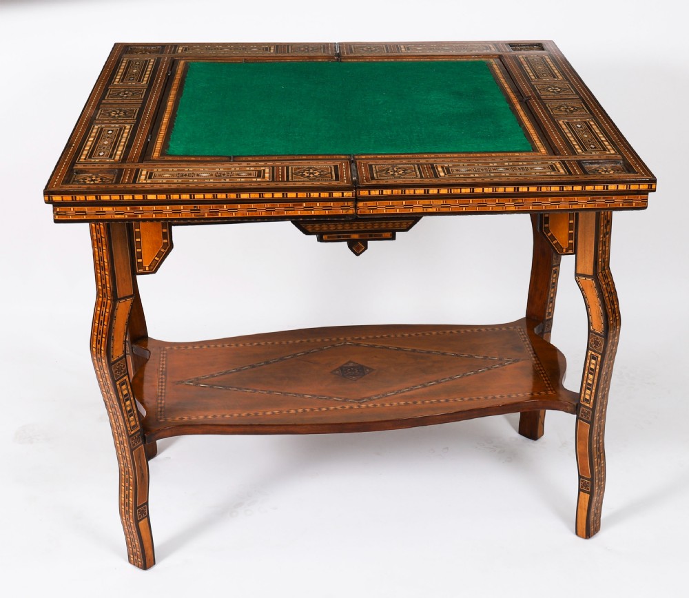 A nineteenth-century wooden games table decorated with geometric micro-mosaic marquetry, mother-of-pearl inlay, cabriole legs, and a lower shelf. View X