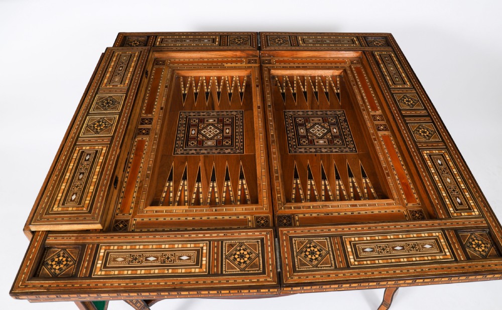 A nineteenth-century wooden games table decorated with geometric micro-mosaic marquetry, mother-of-pearl inlay, cabriole legs, and a lower shelf. View XIII