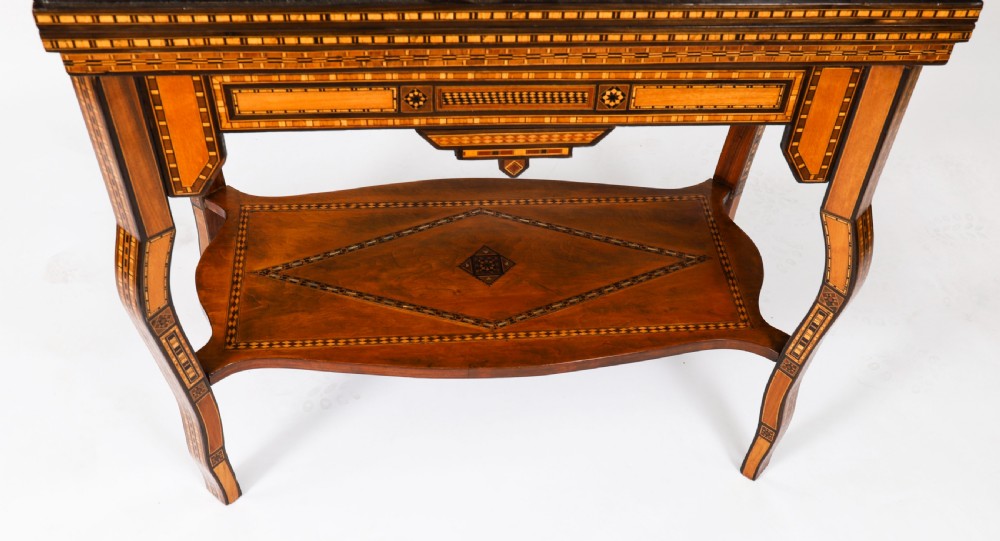 A nineteenth-century wooden games table decorated with geometric micro-mosaic marquetry, mother-of-pearl inlay, cabriole legs, and a lower shelf. View XVI