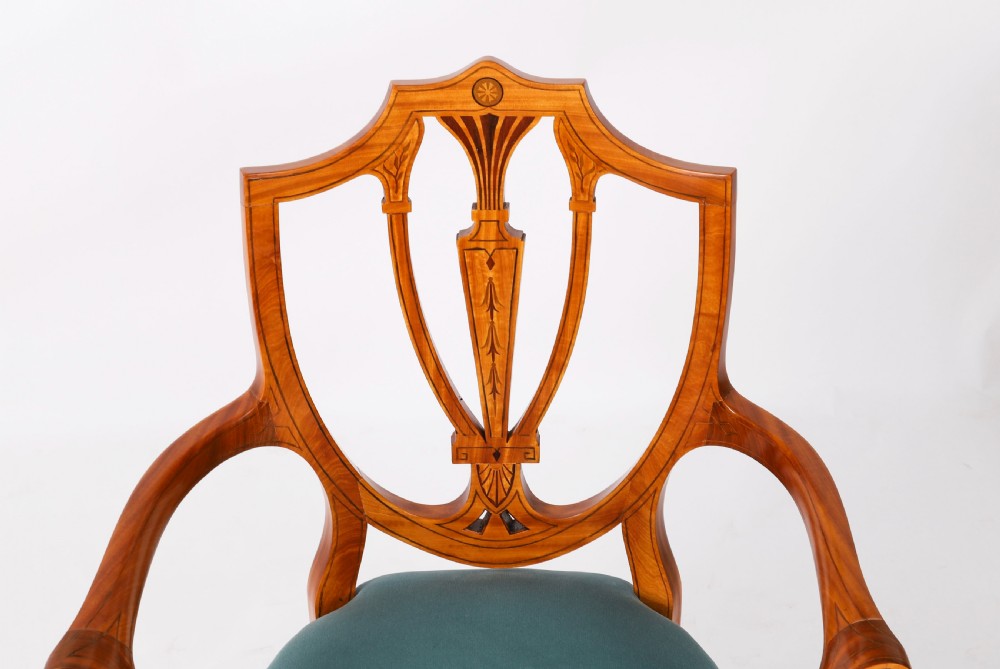 A set of eight antique satinwood shieldback dining chairs featuring classical marquetry inlay and teal velvet seats. View V