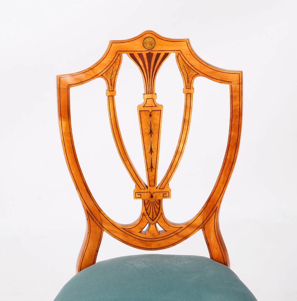 A set of eight antique satinwood shieldback dining chairs featuring classical marquetry inlay and teal velvet seats. View XV