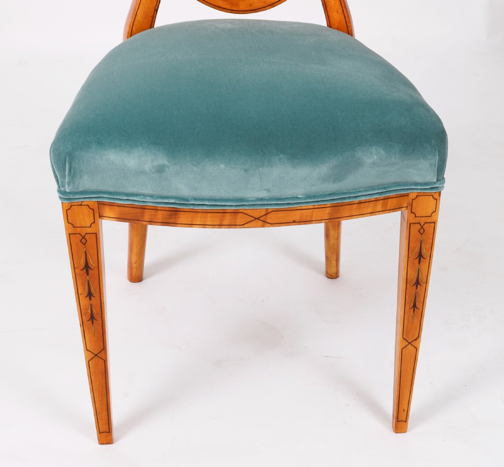 A set of eight antique satinwood shieldback dining chairs featuring classical marquetry inlay and teal velvet seats. View XVII