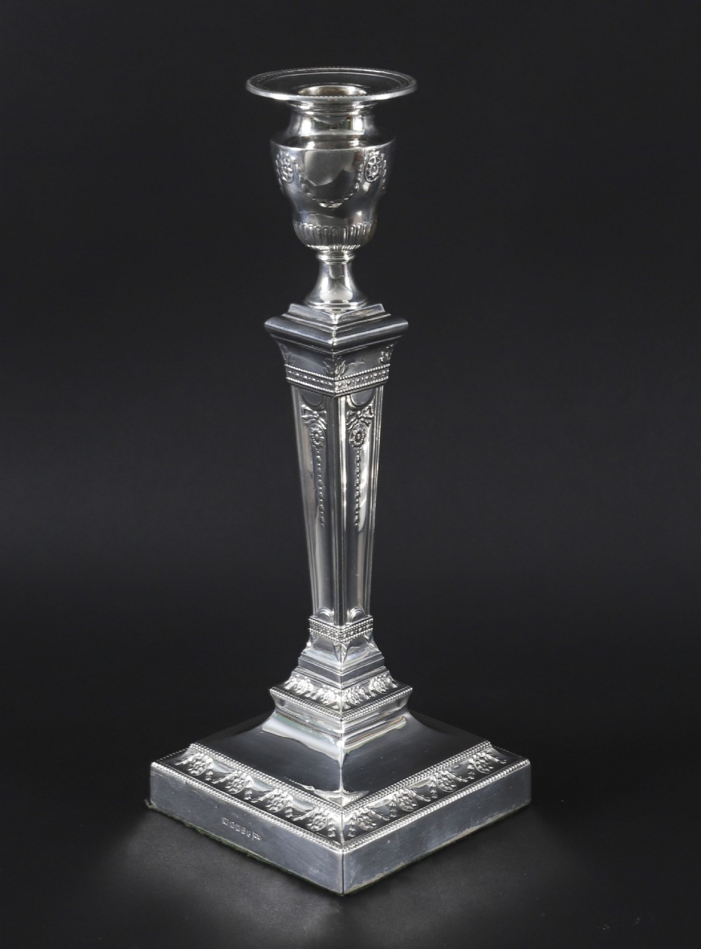 A pair of 19th-century silver-plated Neo-Classical candlesticks with tapered square shafts, urn-shaped nozzles, and festoon decoration on square bases. View XII