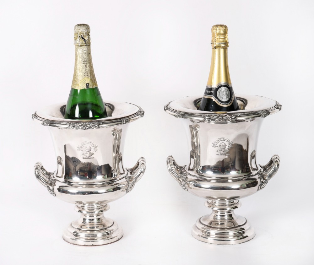 A pair of silver-plated urn-shaped wine coolers featuring scrolled side handles, engraved central crests, and circular pedestal bases. View II