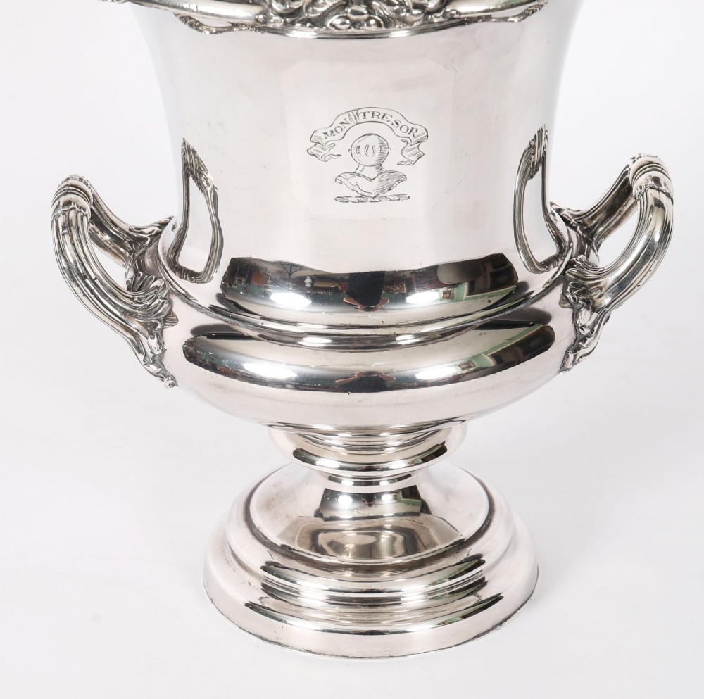 A pair of silver-plated urn-shaped wine coolers featuring scrolled side handles, engraved central crests, and circular pedestal bases. View IV
