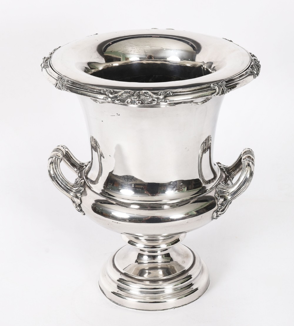 A pair of silver-plated urn-shaped wine coolers featuring scrolled side handles, engraved central crests, and circular pedestal bases. View XI