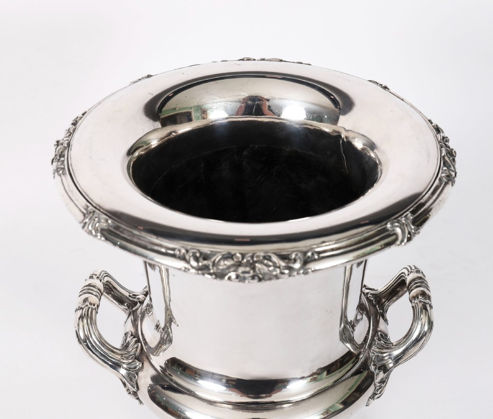 A pair of silver-plated urn-shaped wine coolers featuring scrolled side handles, engraved central crests, and circular pedestal bases. View XIII