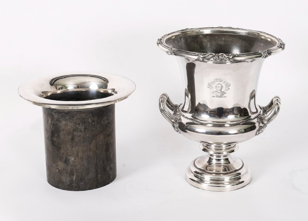 A pair of silver-plated urn-shaped wine coolers featuring scrolled side handles, engraved central crests, and circular pedestal bases. View XV