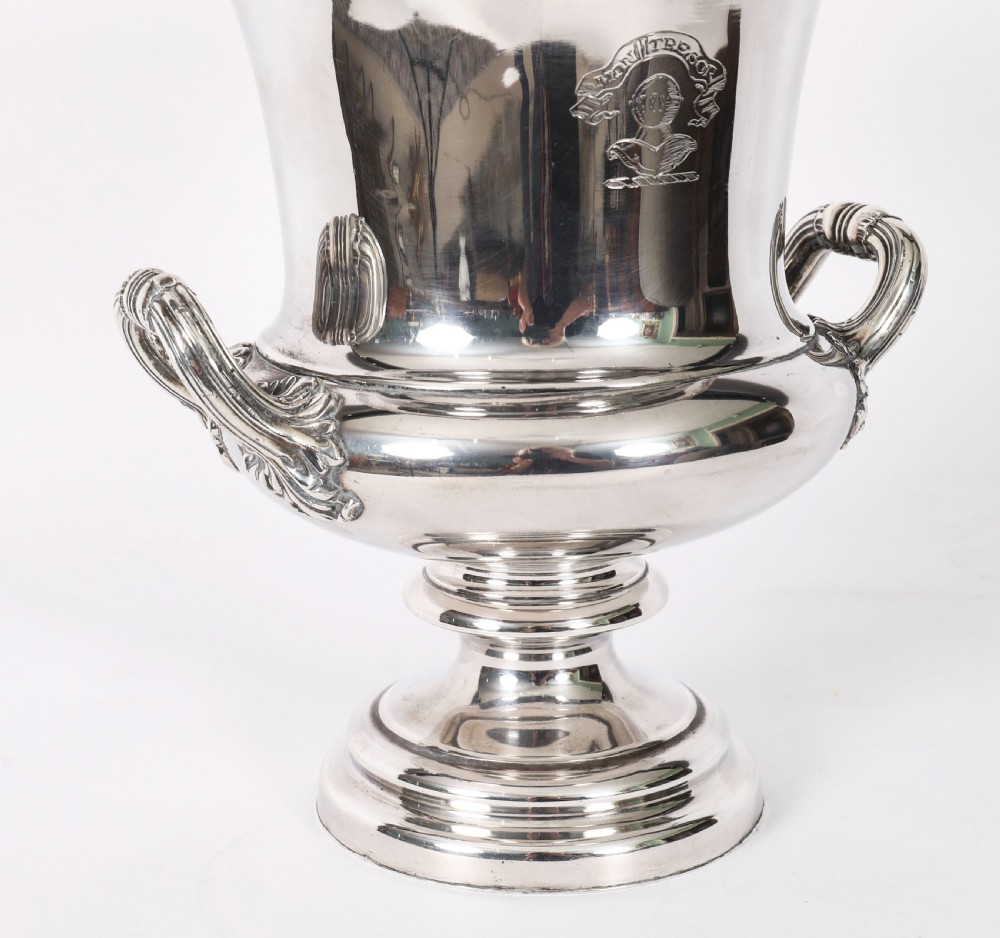 A pair of silver-plated urn-shaped wine coolers featuring scrolled side handles, engraved central crests, and circular pedestal bases. View XVI