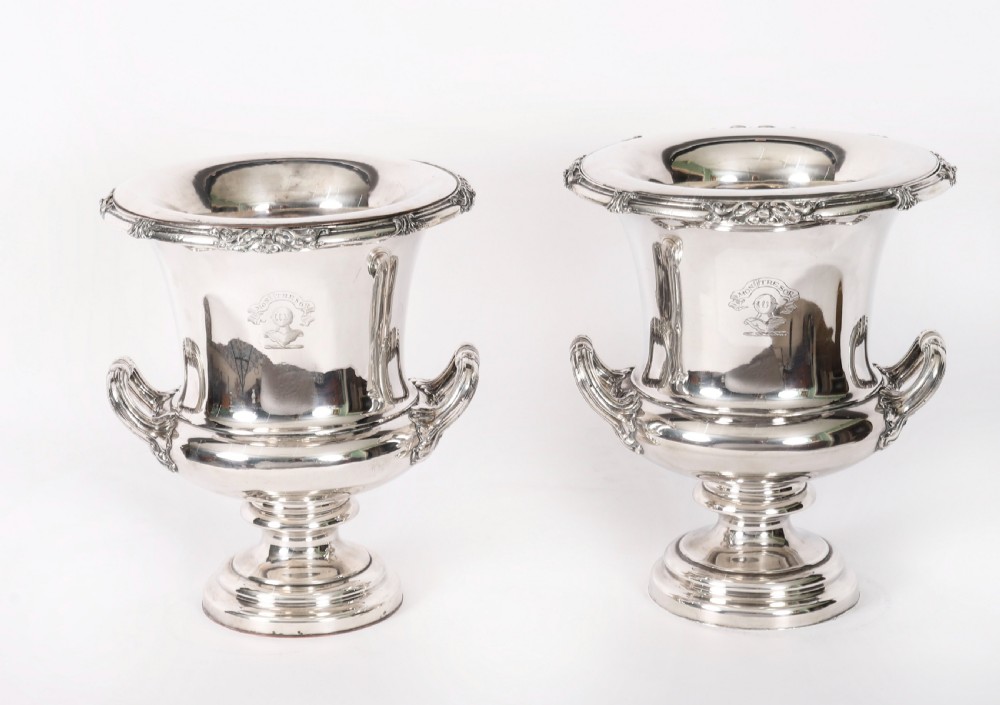 A pair of silver-plated urn-shaped wine coolers featuring scrolled side handles, engraved central crests, and circular pedestal bases. View XX