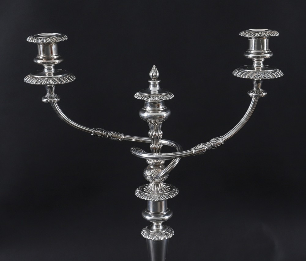 A pair of silver three-light candelabra featuring fluted columns, reeded scrolling branches, and gadrooned rims on circular bases. View IX