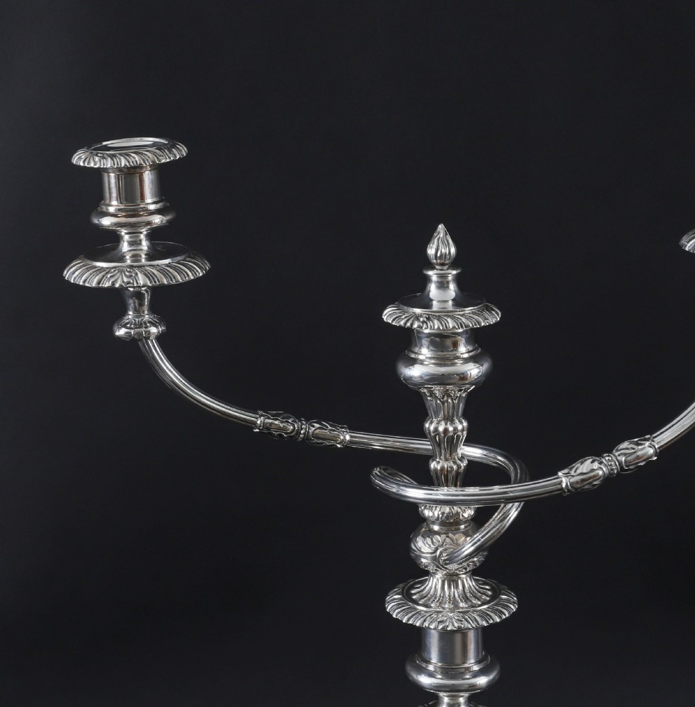 A pair of silver three-light candelabra featuring fluted columns, reeded scrolling branches, and gadrooned rims on circular bases. View X