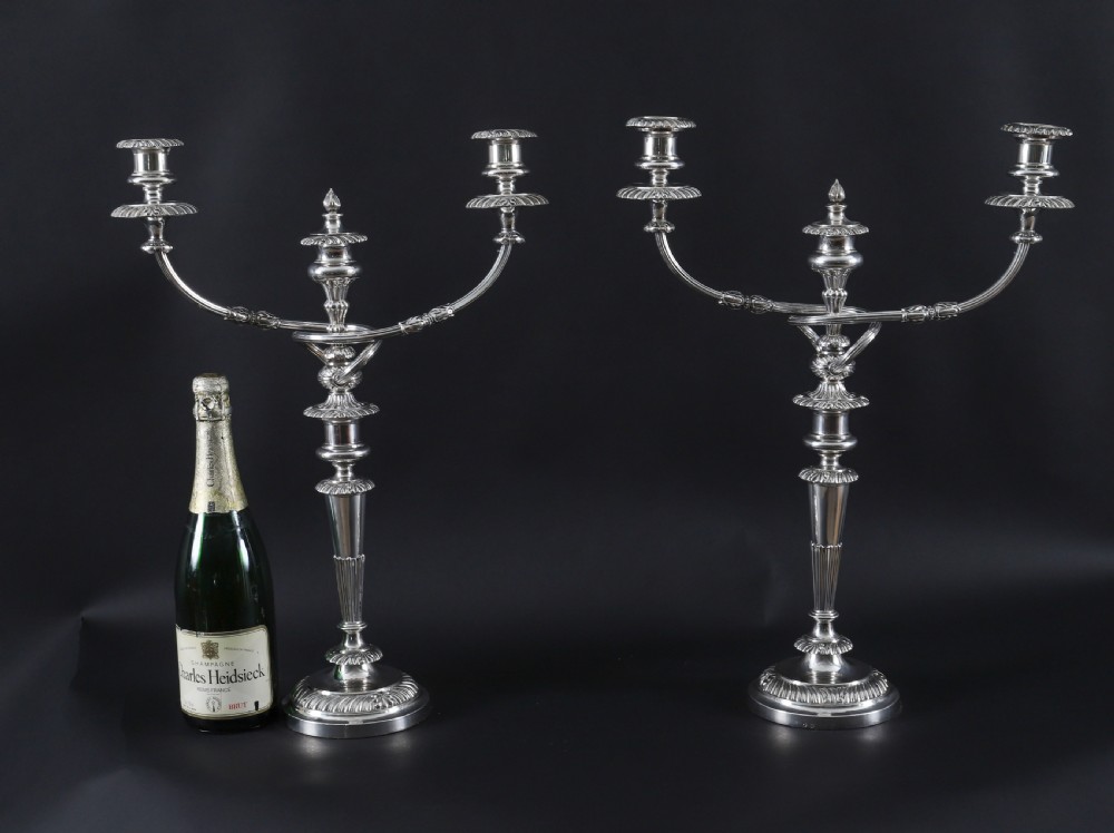 A pair of silver three-light candelabra featuring fluted columns, reeded scrolling branches, and gadrooned rims on circular bases. View XIX