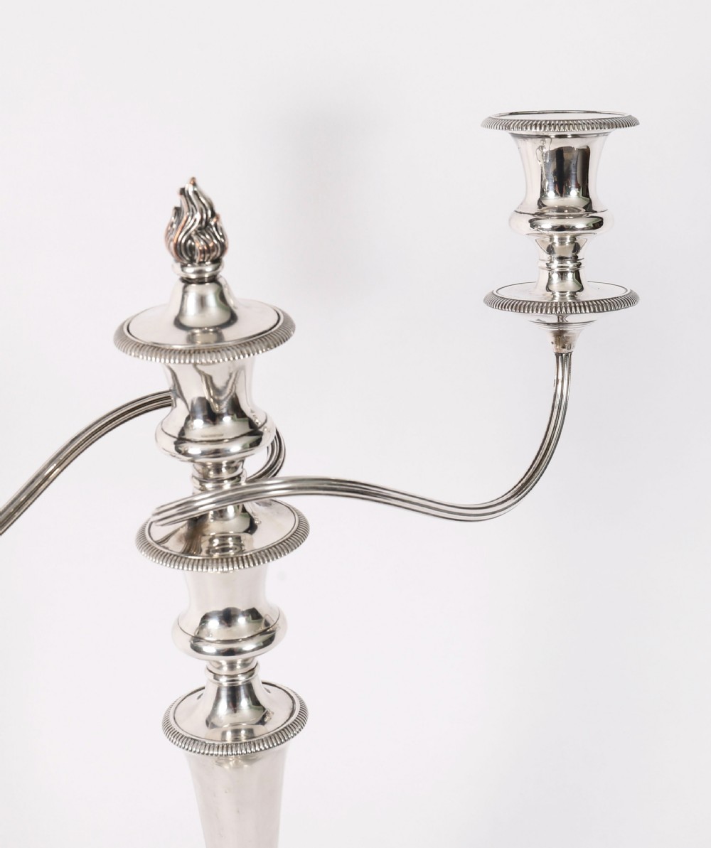 A pair of late nineteenth-century silver three-light candelabra featuring reeded curving arms, beaded circular bases, and central flame finials. View VI