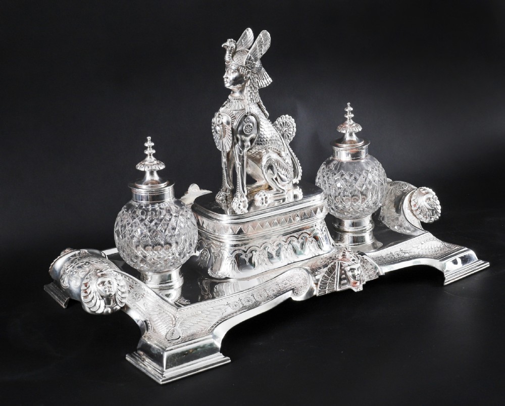 A Victorian silver-plated inkstand featuring a central winged sphinx sculpture flanked by two cut glass inkwell bottles. View II