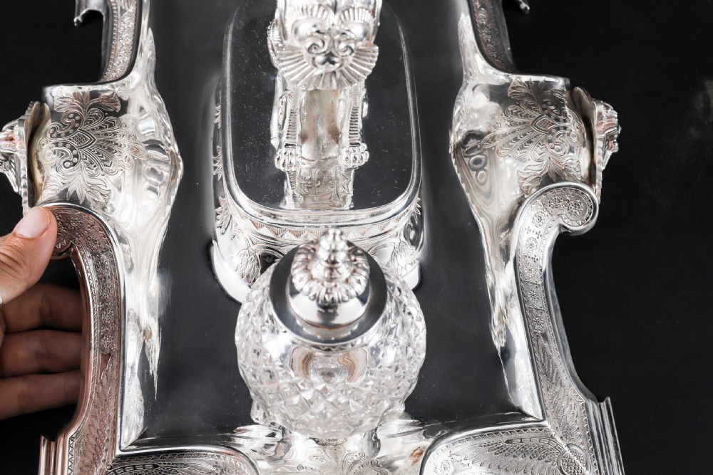 A Victorian silver-plated inkstand featuring a central winged sphinx sculpture flanked by two cut glass inkwell bottles. View V
