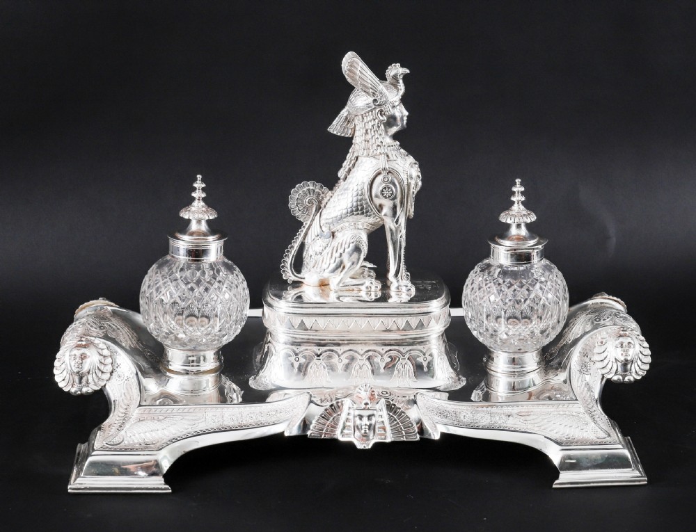 A Victorian silver-plated inkstand featuring a central winged sphinx sculpture flanked by two cut glass inkwell bottles. View VII