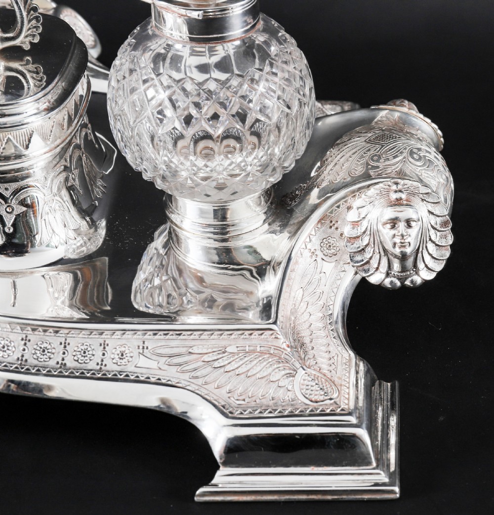 A Victorian silver-plated inkstand featuring a central winged sphinx sculpture flanked by two cut glass inkwell bottles. View X