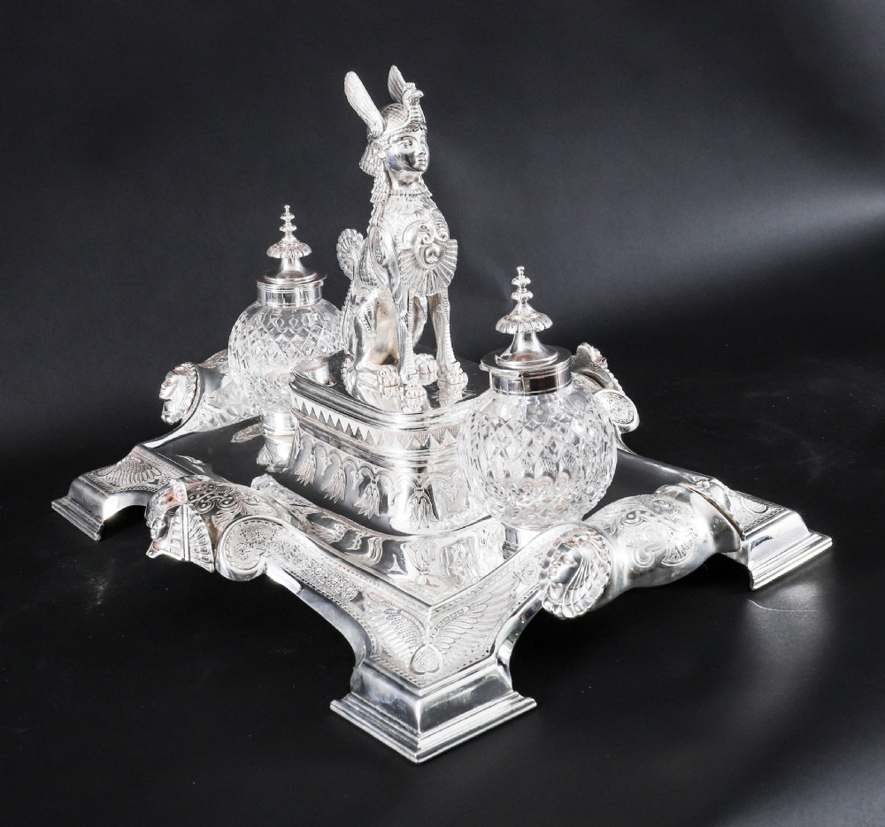 A Victorian silver-plated inkstand featuring a central winged sphinx sculpture flanked by two cut glass inkwell bottles. View XII