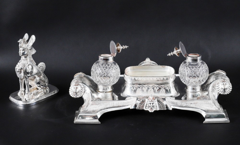 A Victorian silver-plated inkstand featuring a central winged sphinx sculpture flanked by two cut glass inkwell bottles. View XIII