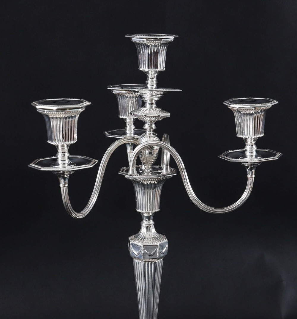 A pair of silver-plated four-light candelabra featuring fluted tapered stems, octagonal stepped bases, and curved reeded arms. View X