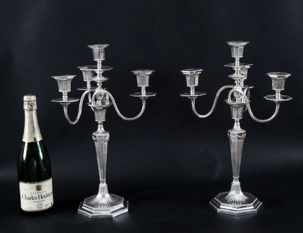 A pair of silver-plated four-light candelabra featuring fluted tapered stems, octagonal stepped bases, and curved reeded arms. View XVI