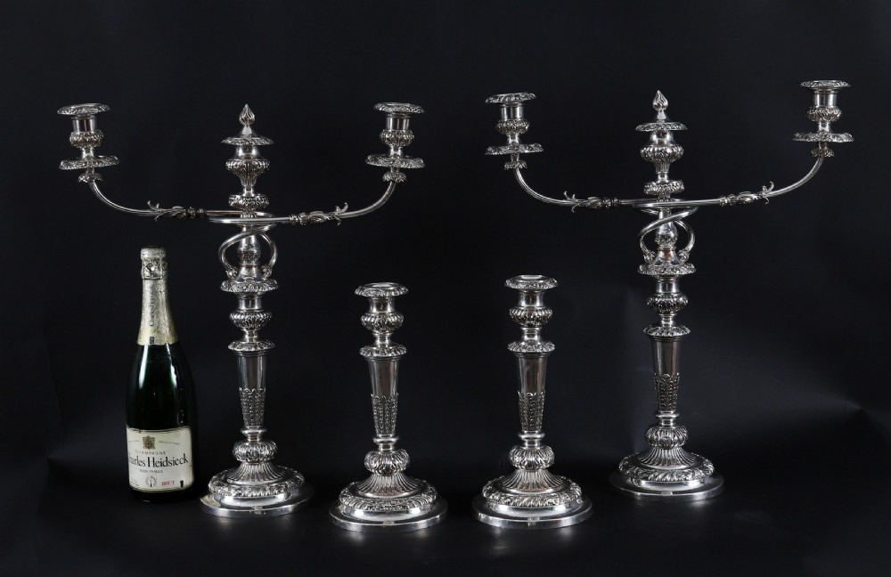 A four-piece set of 18th-century George III Old Sheffield silver-plated candelabra and matching candlesticks with fluted stems and leaf motifs. View XIX