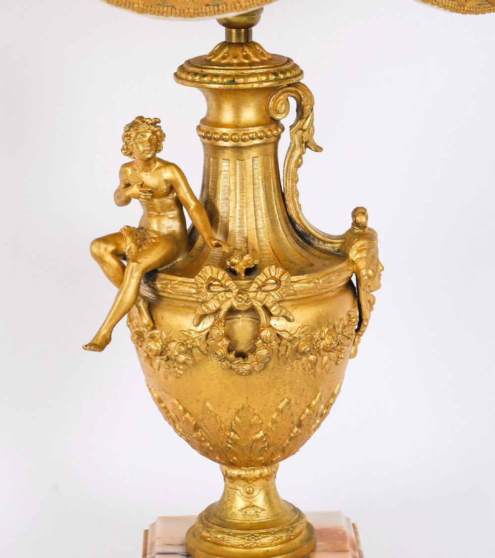 A pair of Neoclassical ormolu urn-form table lamps featuring classical figures mounted on square pink marble bases with cream pleated shades. View VII