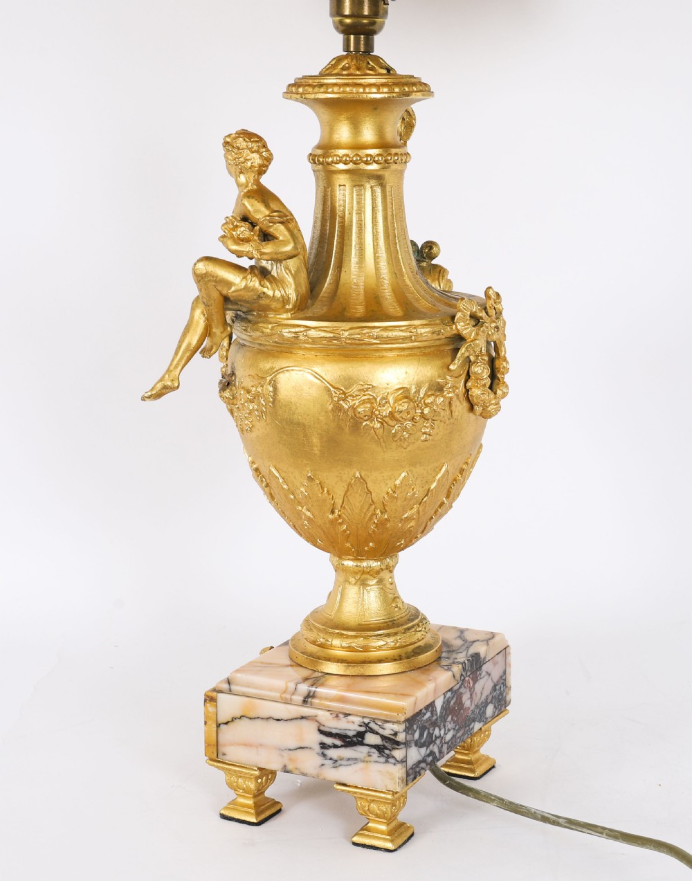 A pair of Neoclassical ormolu urn-form table lamps featuring classical figures mounted on square pink marble bases with cream pleated shades. View XIII