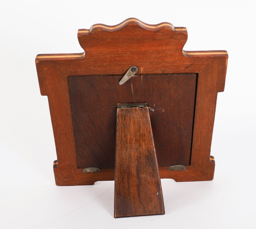 A pair of Edwardian sterling silver photo frames with wooden easel backs and oval apertures lined in red fabric. View VIII