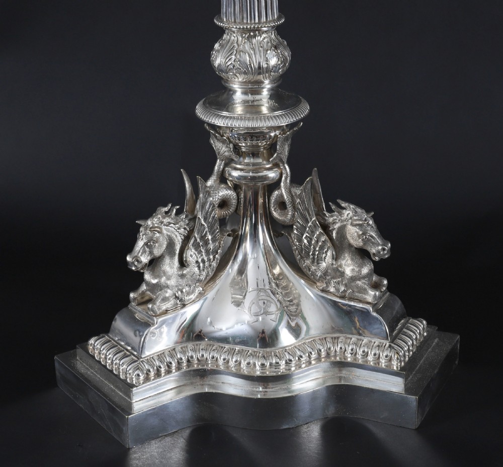 An ornate Victorian silver-plated multi-arm table centrepiece candelabra featuring scrollwork branches, a fluted column stem, and a pediment base adorned with mythical creatures. View XII